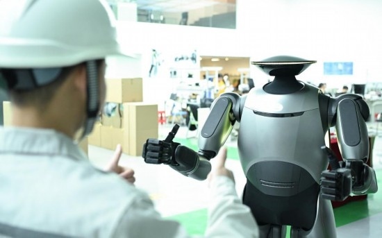 在廣汽研究院，人形機器人團隊的周仁義在演示GoMate機器人互動功能（新華社記者 鄧華 攝）