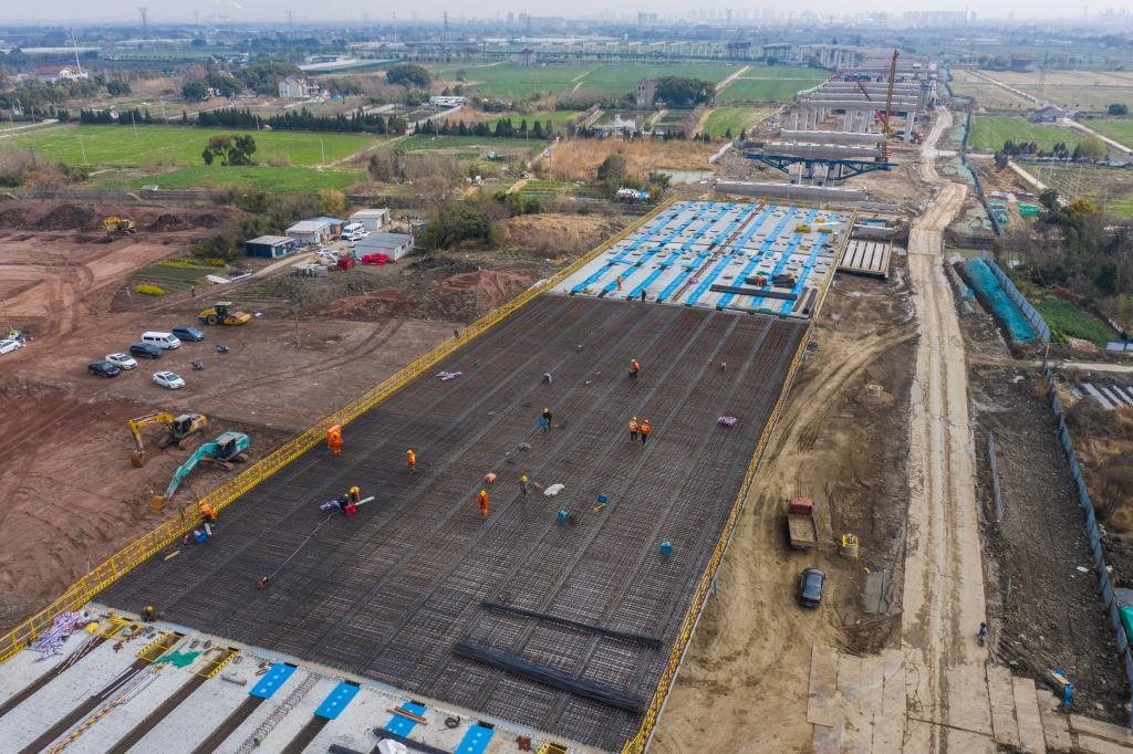 3月7日，在524國道秀洲王江涇至新塍公路工程TJ02標(biāo)段，作業(yè)人員正在進(jìn)行60米鋼混組合梁現(xiàn)澆橋面板鋼筋焊接及綁扎作業(yè)（無人機(jī)照片）。新華社記者 徐昱 攝