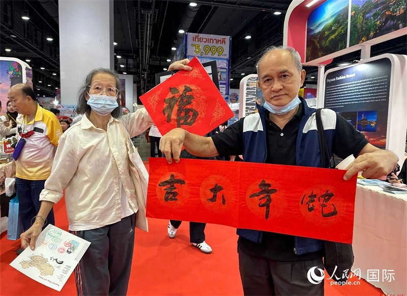 2025蛇年春節(jié)，泰國市民展示他們領(lǐng)到的華人手寫春聯(lián)。人民網(wǎng)記者 簡承淵攝