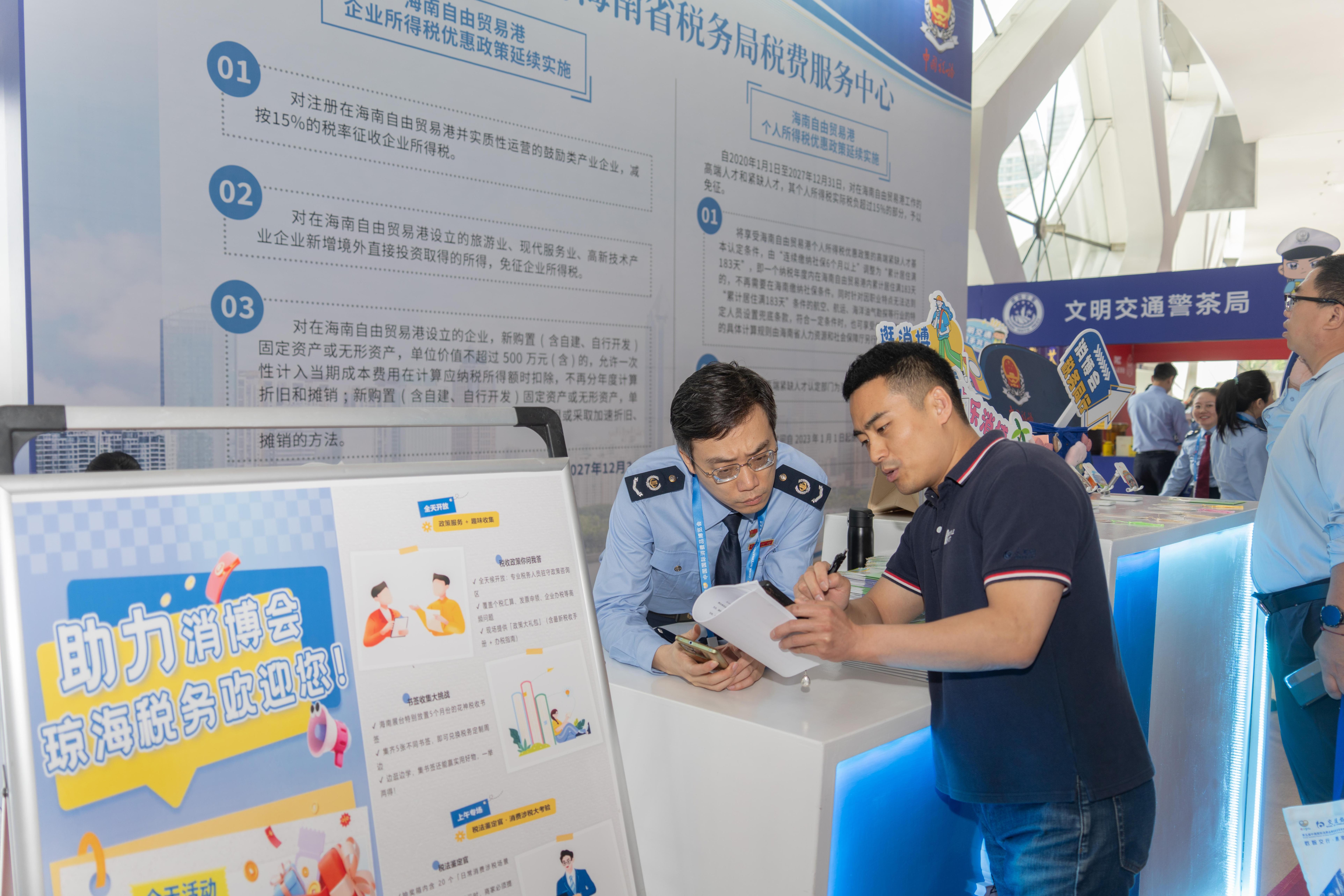 稅務(wù)服務(wù)臺(tái)工作人員向記者介紹服務(wù)參展外商的具體舉措。人民網(wǎng)記者 許崢攝
