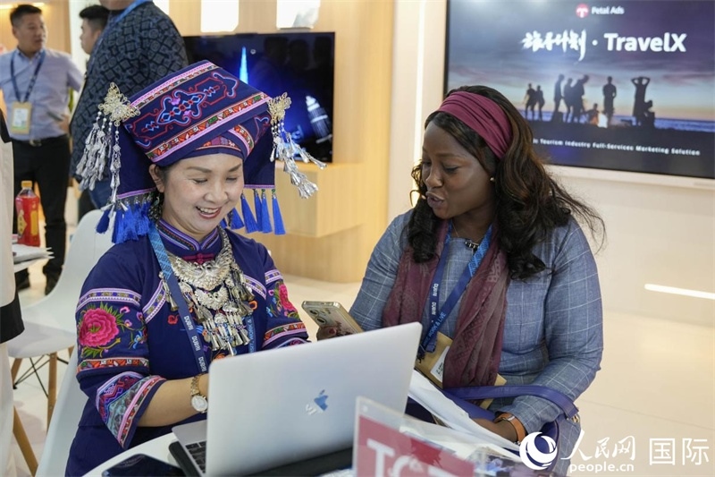 來自廣西的旅游業(yè)者同客戶交流。人民網(wǎng)塔里克·易卜拉欣攝