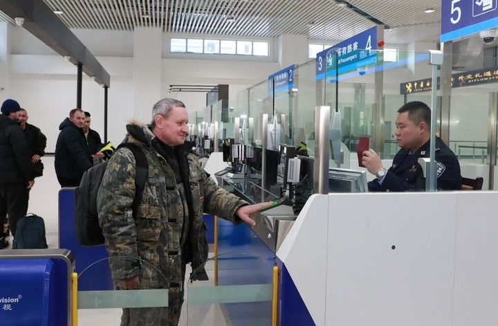 2024年12月10日，在黑河公路口岸旅檢大廳，黑河出入境邊防檢查站民警為首班次客車入境旅客辦理邊檢通關(guān)手續(xù)。當(dāng)日，中國黑河公路口岸—俄羅斯卡尼庫爾干公路口岸旅客運(yùn)輸正式開通。新華社發(fā)（劉松攝）