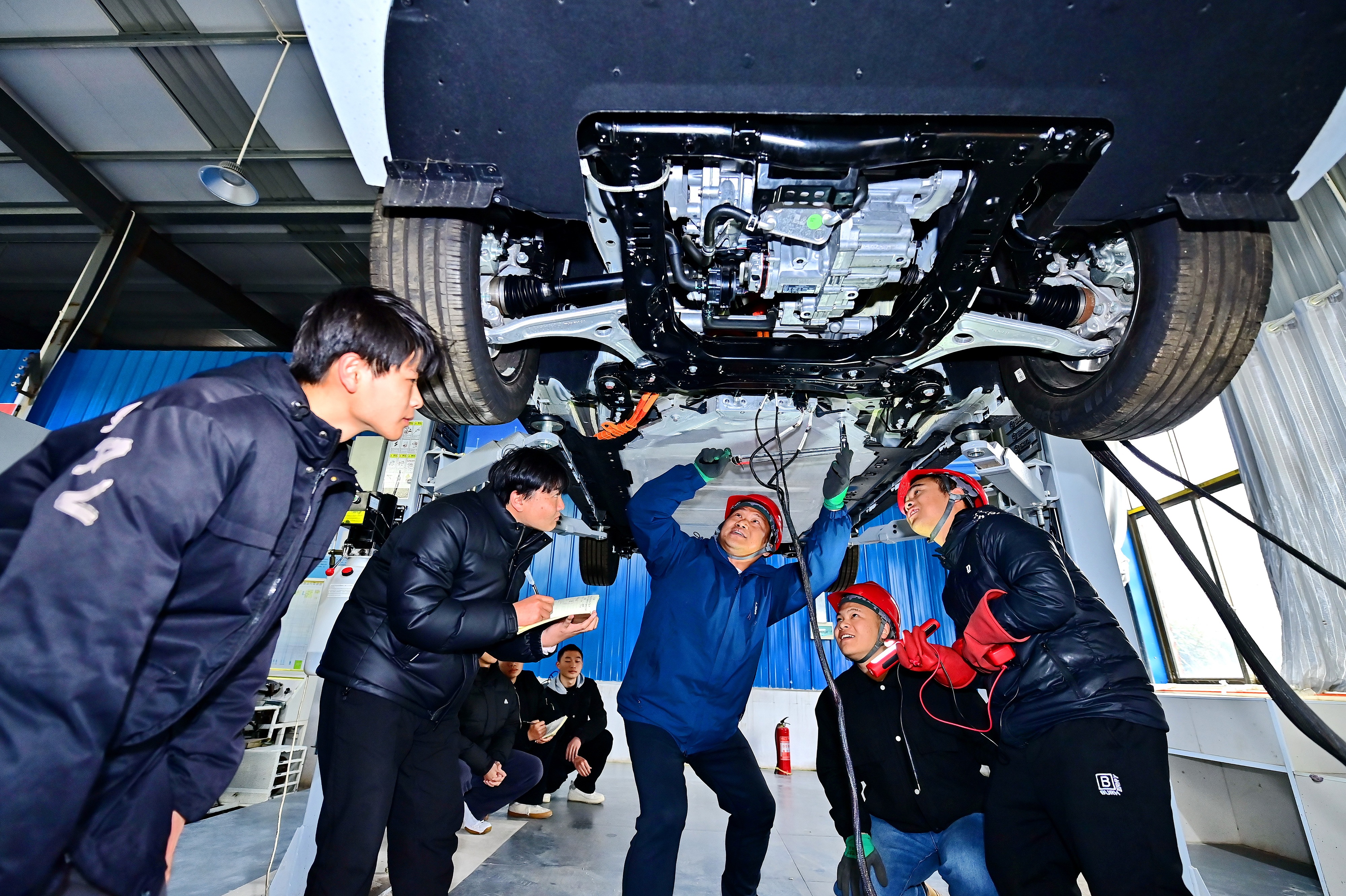 2025年2月，江西省宜春市，豐城市的一所技工學(xué)校實(shí)訓(xùn)基地內(nèi)，新能源汽車運(yùn)維專業(yè)學(xué)生在老師的指導(dǎo)下學(xué)習(xí)新能源汽車電池包檢修技術(shù)。