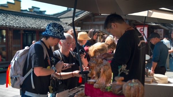 “五一”期間，游客正在烏鎮(zhèn)“水鄉(xiāng)碼頭”挑選購買文創(chuàng)產(chǎn)品。受訪者供圖