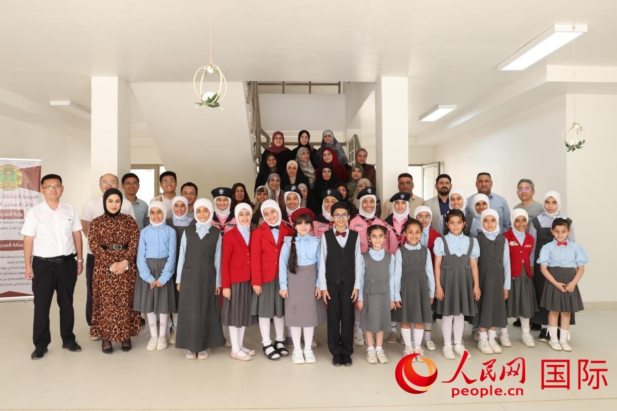 中國(guó)電建員工與阿爾穆塔?阿里卡特國(guó)際學(xué)校的師生及政府官員等合影。人民網(wǎng)記者 薛丹攝