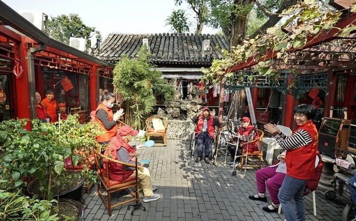 2024年10月12日，鐘樓灣胡同的老年人在社區(qū)內(nèi)的四合院養(yǎng)老驛站休閑。2017年起，北京市先后開展了兩輪背街小巷環(huán)境整治提升行動，完整保留了中軸線生活建筑群的歷史信息，并根據(jù)居民的生活和居住方式進行適配化的更新和改造，極大地改善了生活環(huán)境。2023年鐘樓灣胡同被評為“北京最美街巷”。