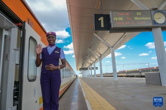 5月31日，在蒙內(nèi)鐵路內(nèi)羅畢站，一名乘務員在即將開往蒙巴薩的E2次列車旁等候乘客。新華社記者 楊光 攝