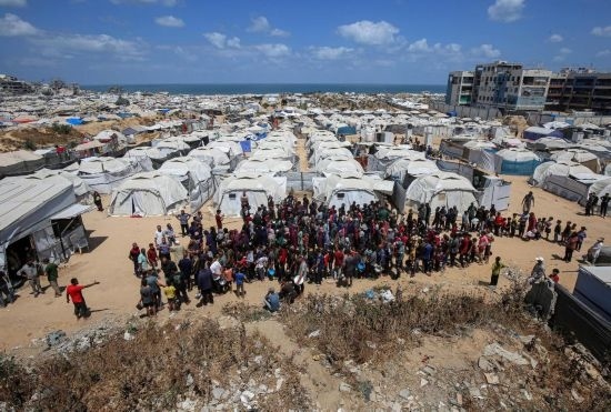 5月28日，人們在加沙城西部的沙提難民營等待領(lǐng)取救助食物。新華社發(fā)（里澤克·阿卜杜勒賈瓦德攝）