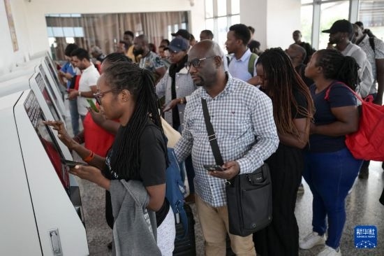 5月31日，在蒙內(nèi)鐵路內(nèi)羅畢站，乘客在自助取票機前排隊取票。新華社記者 楊光 攝