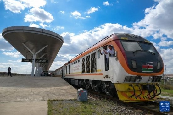 5月31日，在蒙內(nèi)鐵路內(nèi)羅畢站，機車駕駛員蔣立平（右）和博爾在即將開往蒙巴薩的E2次列車上揮手致意。新華社記者 楊光 攝