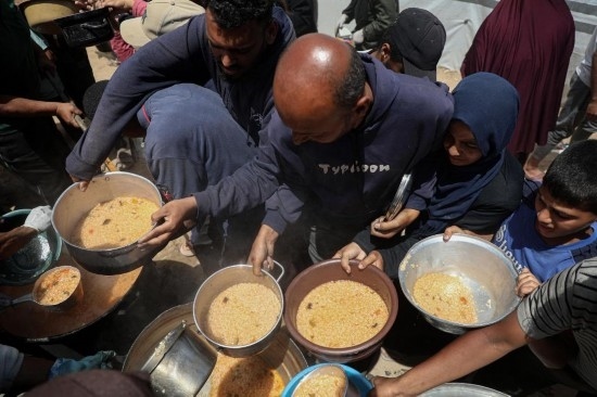 5月28日，人們在加沙城西部的沙提難民營領(lǐng)取救助食物。新華社發(fā)（里澤克·阿卜杜勒賈瓦德攝）